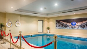 A swimming pool with a red rope barrier, a mural of a swimmer, and two life rings on the wall. - Al Muhaidb Residence Al Malaz 2 - Economic (Riyadh)