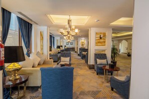 A hotel lobby with a long seating area, a chandelier, and a fire extinguisher. - Al MuhaidbResidence Al Takhasossi 1 - Economic (Riyadh)