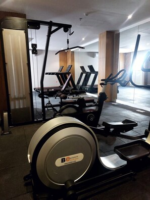 A gym with treadmills, a rowing machine, and a stationary bike. - Al MuhaidbResidence Al Takhasossi 1 - Economic (Riyadh)