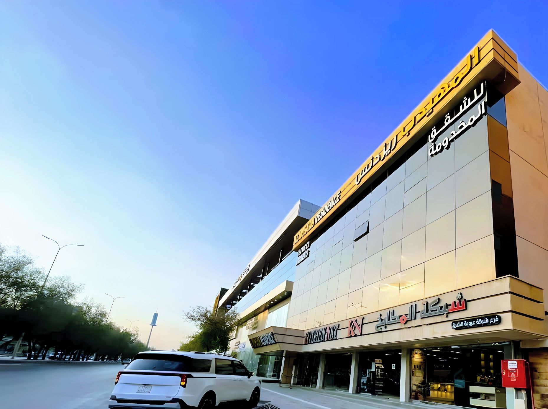 A modern building with a prominent sign in Arabic.