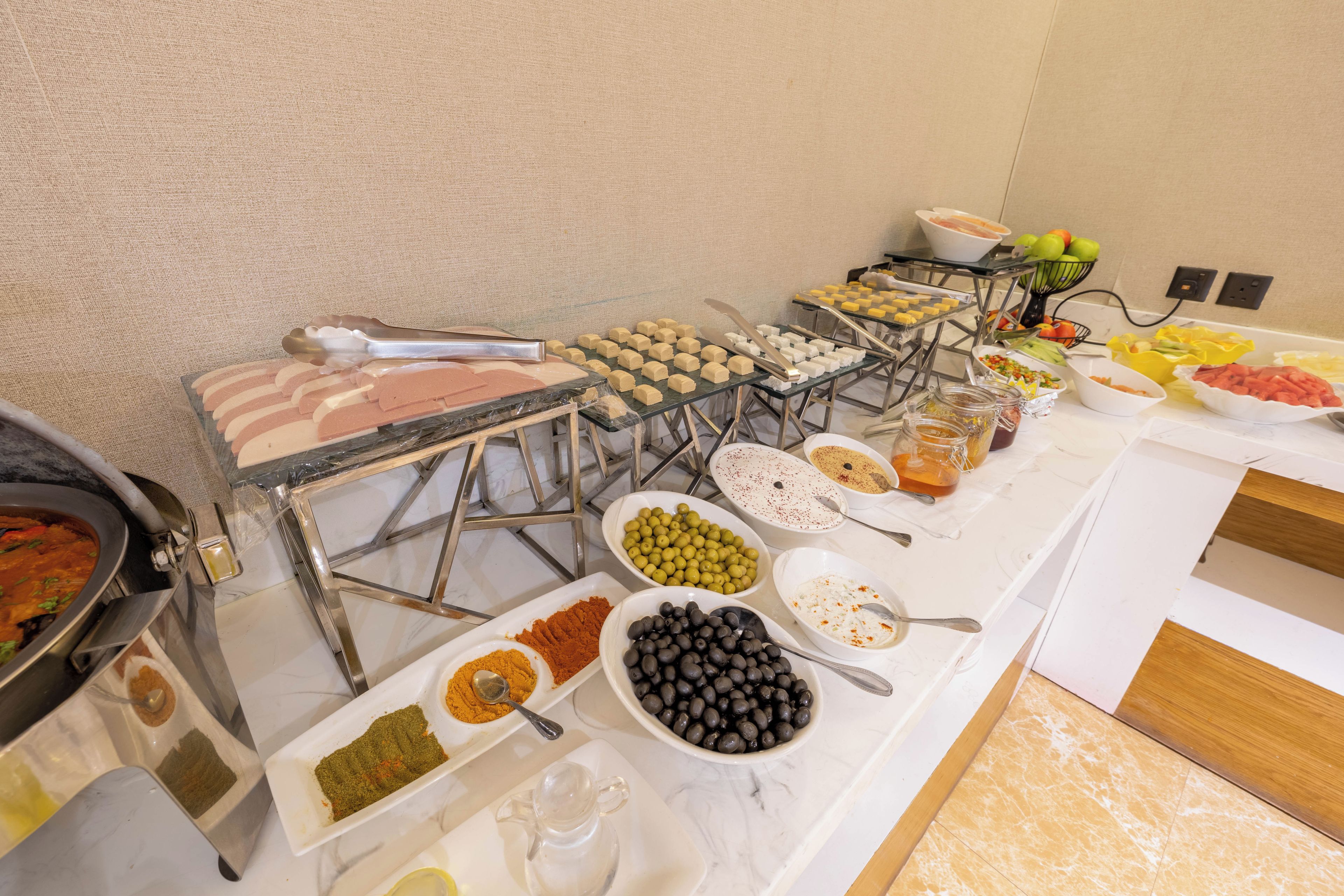 Uma mesa de buffet com diversos alimentos e acompanhamentos.