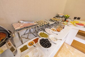 Una mesa de buffet con diversos alimentos y salsas.