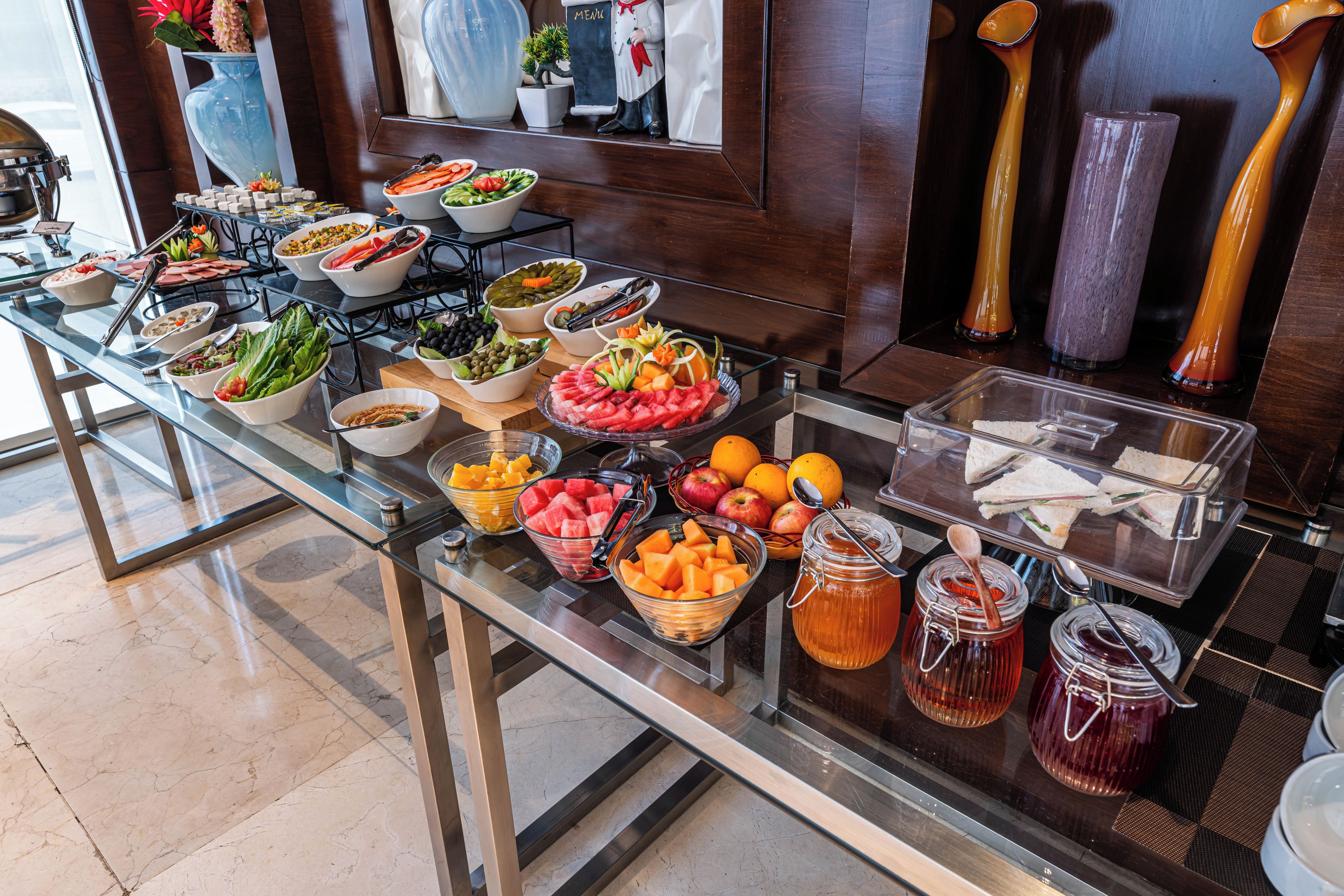 A buffet with various food items and condiments.