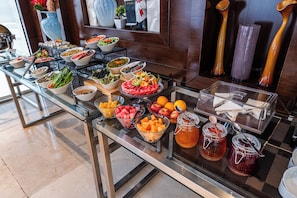 A buffet with various food items and condiments.