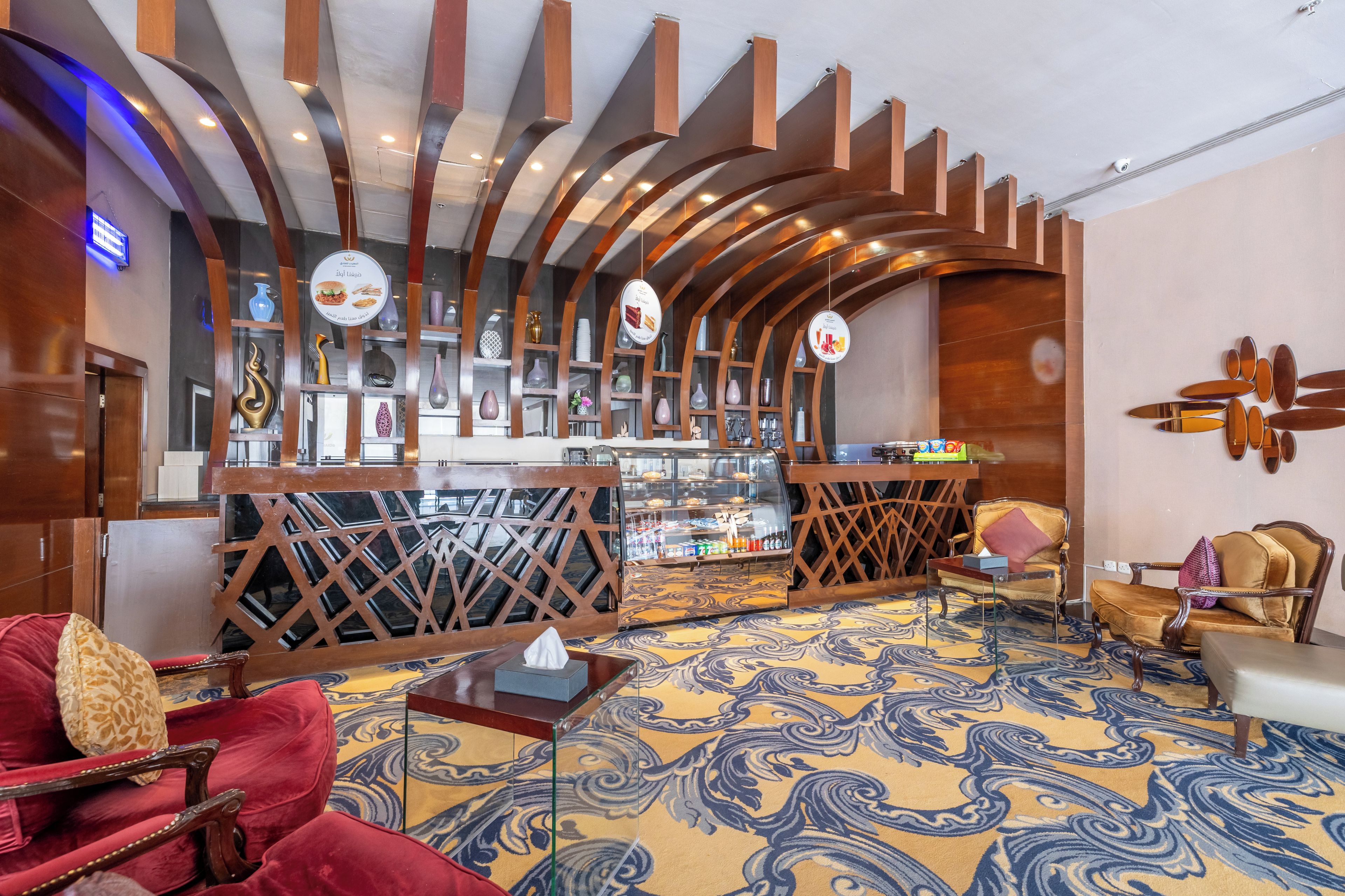 A hotel lobby with a bar area, seating arrangements, and a patterned carpet.