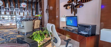 Un moderno vestíbulo de hotel con una recepción, computadora y zona de estar.
