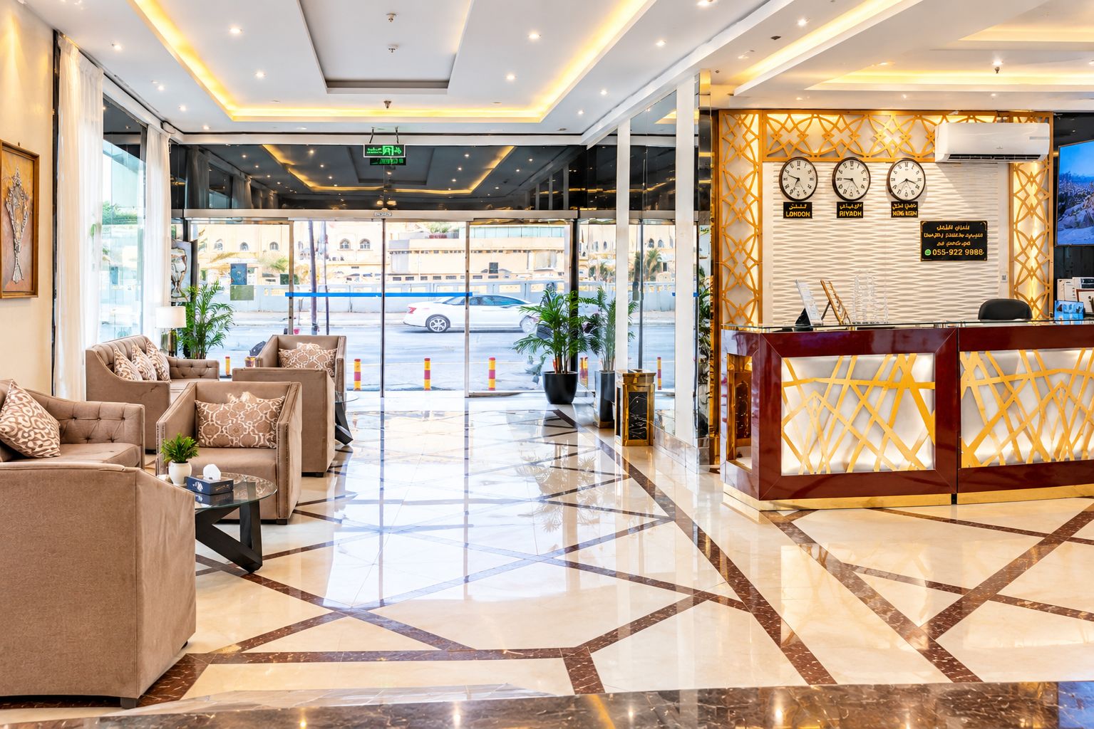 A hotel lobby with a reception desk, seating area, and large windows.