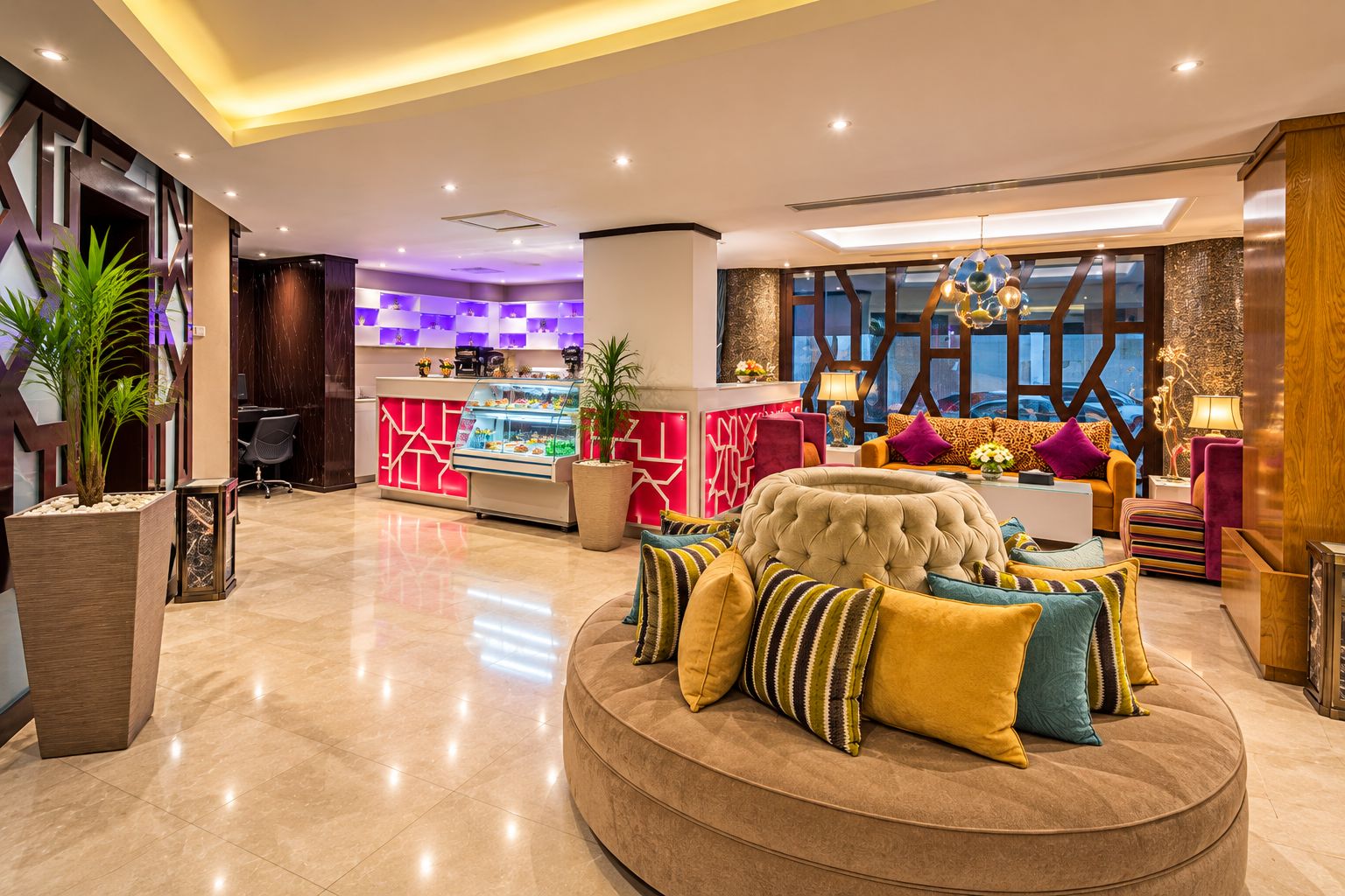 Un hall de hotel con una zona de estar central, una recepción y vistas a la ciudad a trav és de amplios ventanales.