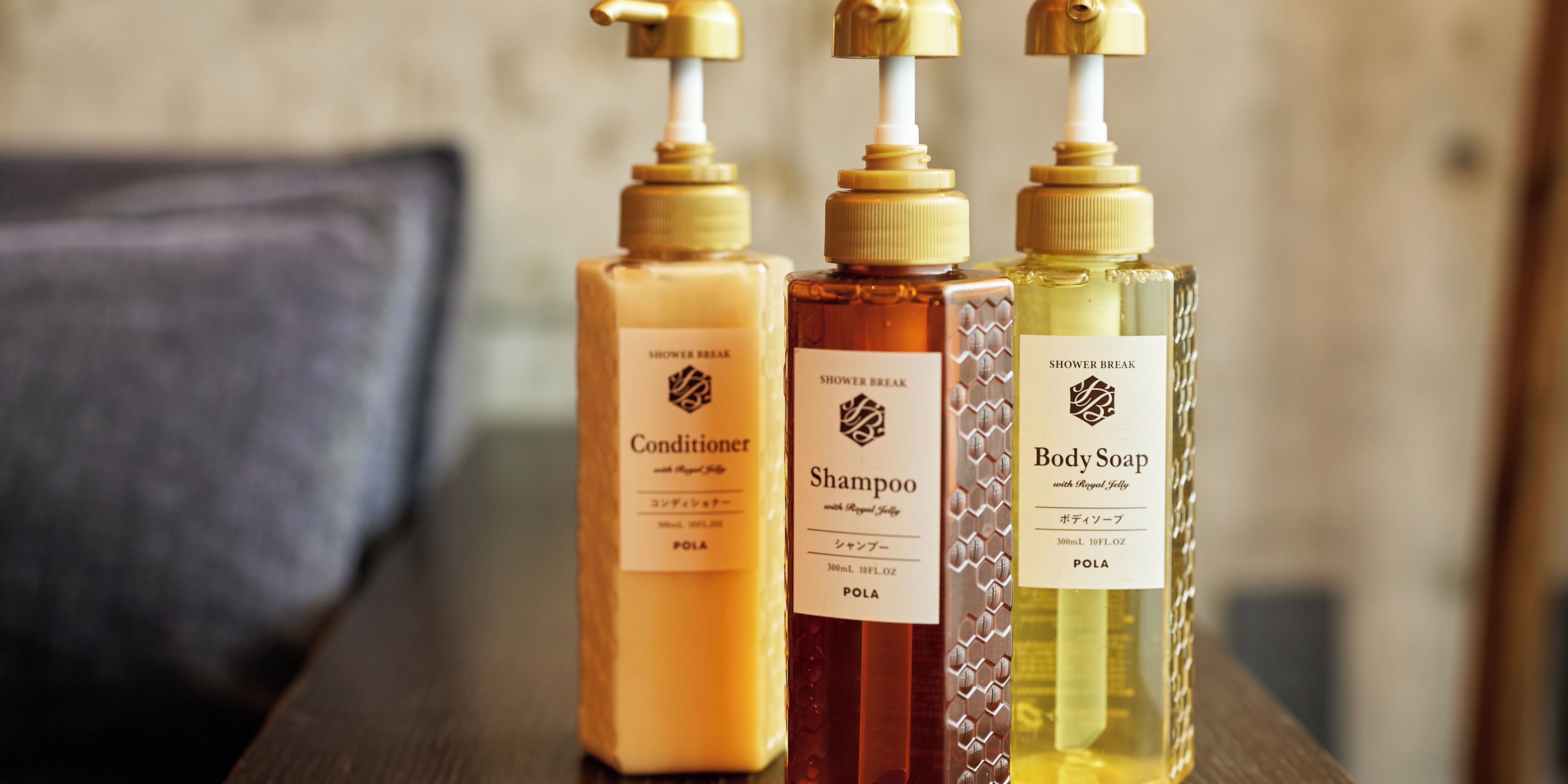 Trois bouteilles de produits pour la douche, posées sur une surface en bois.