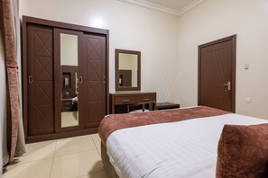 A bedroom with a bed, a dresser, a mirror, and two wardrobes. - Al Muhaidb Residence Al Malaz  6 - Economic (Riyadh)