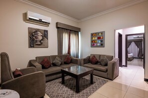 A living room with a sofa set, a coffee table, and a patterned rug. - Al Muhaidb Residence Al Malaz  6 - Economic (Riyadh)