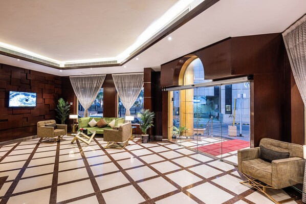 A hotel lobby with a checkered floor, seating area, television, and a glass entrance. - Al Muhaidb Residence Al Malaz  6 - Economic (Riyadh)