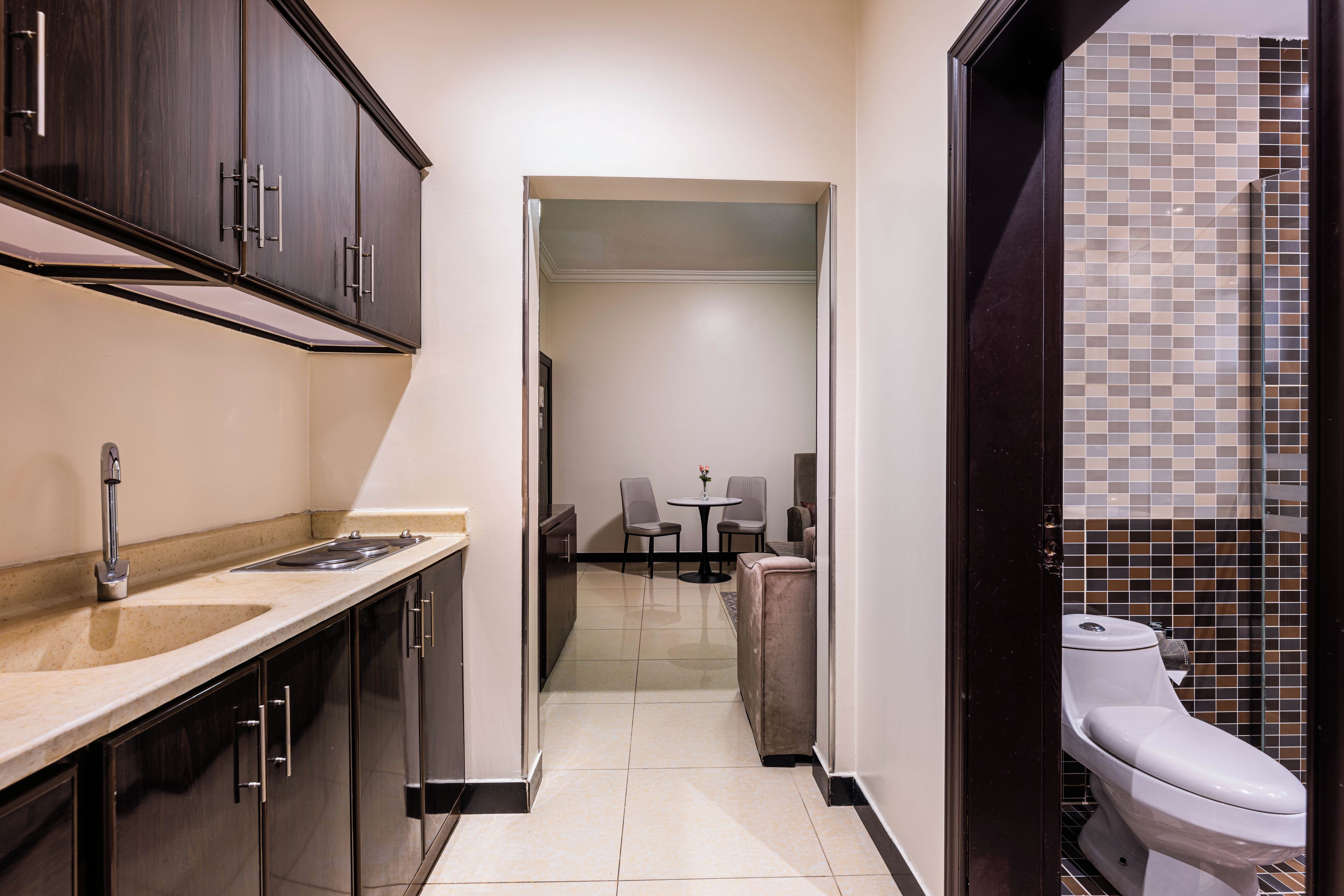 Habitació d'hotel compacta amb cuineta, zona de dinar i bany.