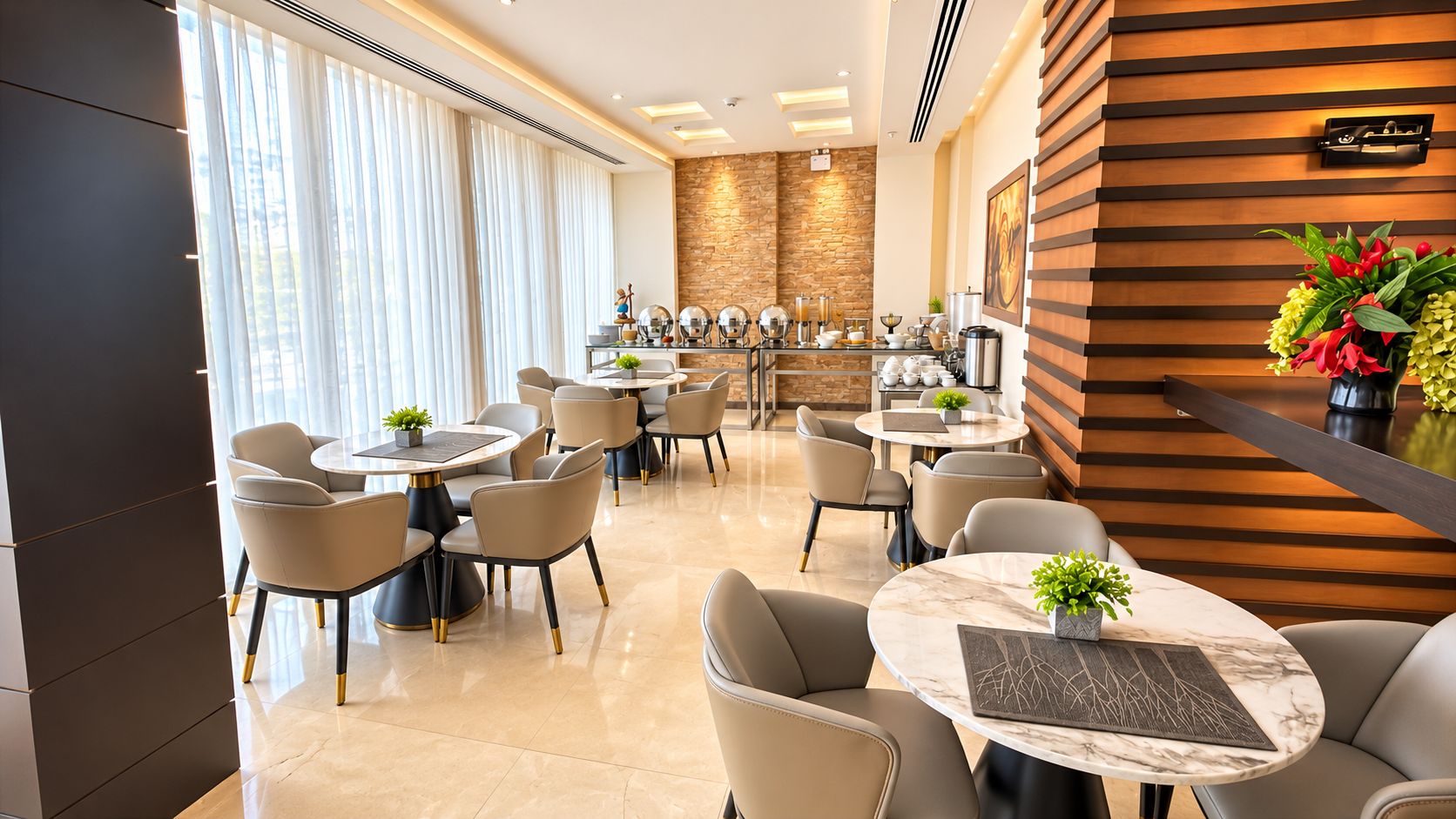 A hotel dining area with round tables and chairs, a stone accent wall, and a wooden panel wall.