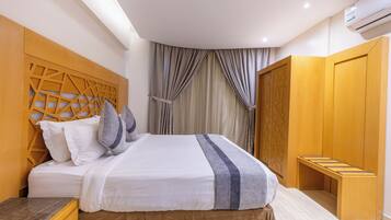 A modern bedroom with a bed, wooden headboard, and a wardrobe.