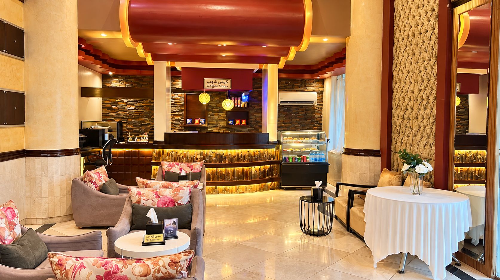 A lobby area with seating, a coffee shop, and a decorative wall.