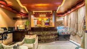 A cozy lobby with a reception desk, seating area, and a coffee shop.