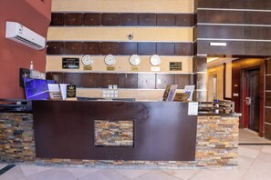 A reception desk with clocks, a water dispenser, and a digital screen. - Al Muhaidb Residence Al Malaz 4 - Economic (Riyadh)