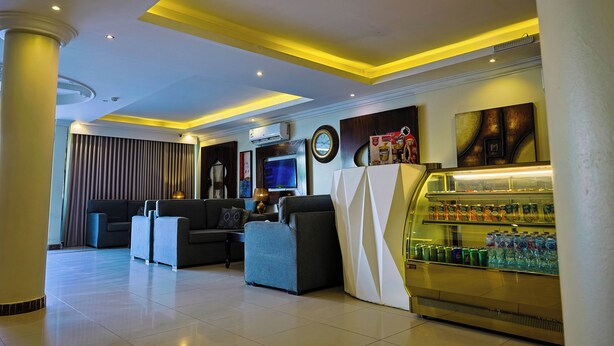 A hotel lobby with a seating area, a refreshment bar, and a television. - DAR NEYAARA SERVICED APARTMENTS - Economic (Riyadh)