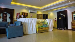 A hotel lobby with seating, a beverage kiosk, and a coat rack. - DAR NEYAARA SERVICED APARTMENTS - Economic (Riyadh)