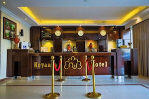 A hotel reception desk with clocks, a reception counter, and a red velvet rope barrier. - DAR NEYAARA SERVICED APARTMENTS - Economic (Riyadh)