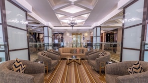 A spacious living area with a central sofa, two armchairs, and a coffee table.