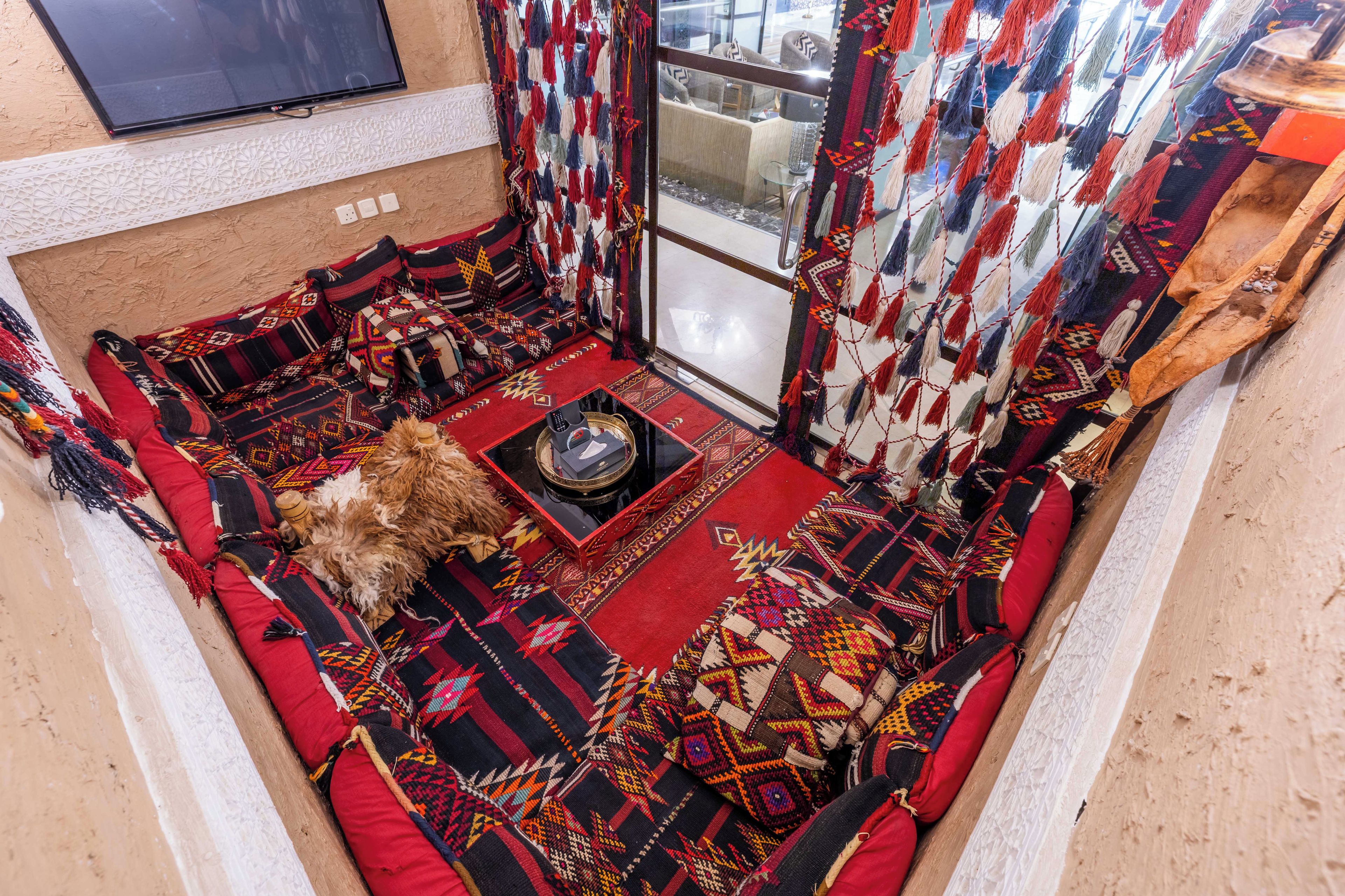 A cozy seating area with a patterned rug, a small table, and a dog.