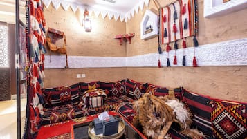 A traditional room with a sofa, a dog, and decorative tassels.