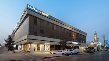 A modern building with large windows and a sign indicating a hotel.