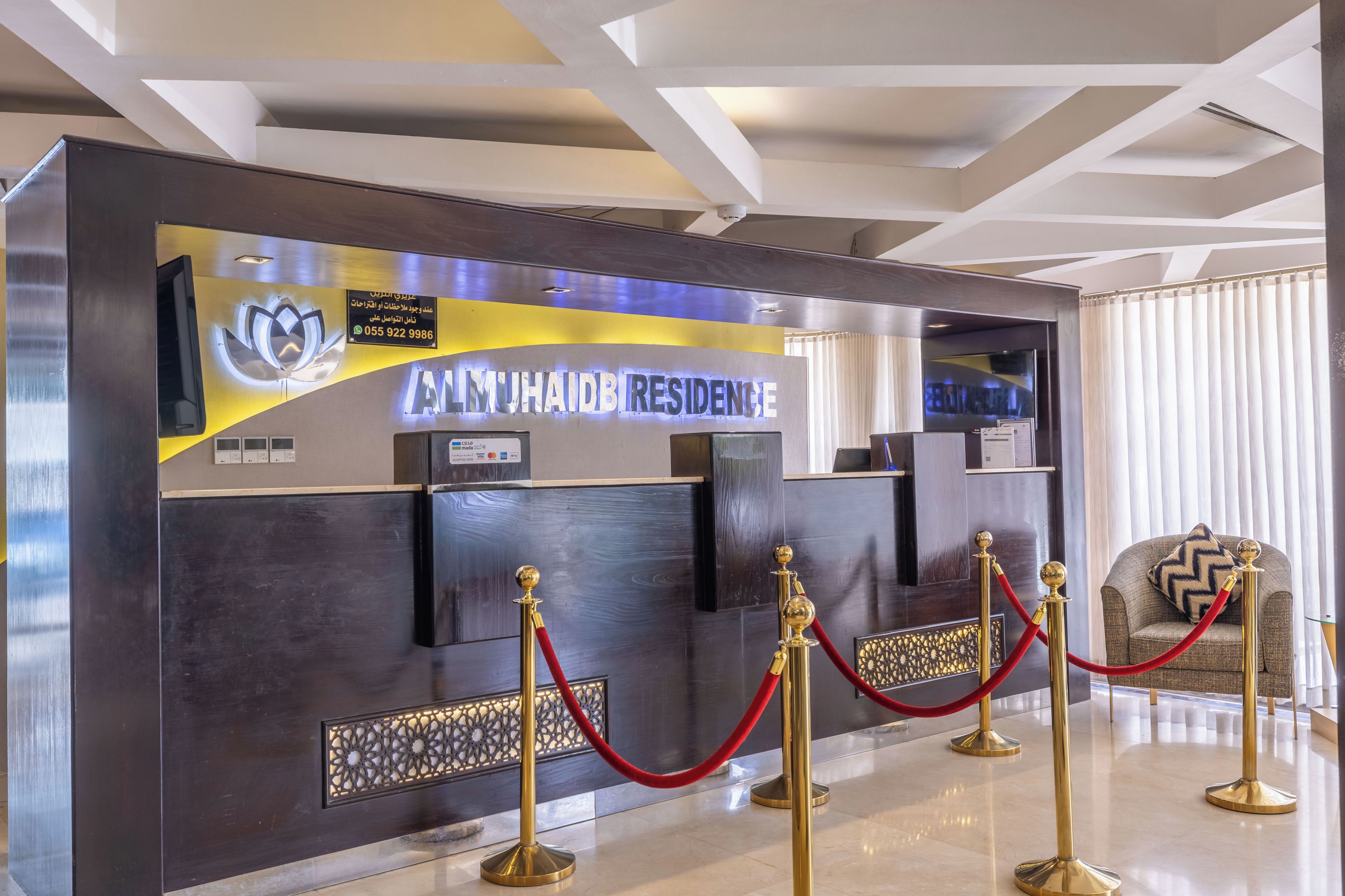 A reception desk with a modern design, featuring a logo and a nameplate.
