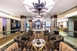 A spacious lobby with a modern chandelier, a central seating area with sofas and a coffee table, and a large TV screen. - Al Muhaidb Residence Al Takhasossi 2 - Economic (Riyadh)
