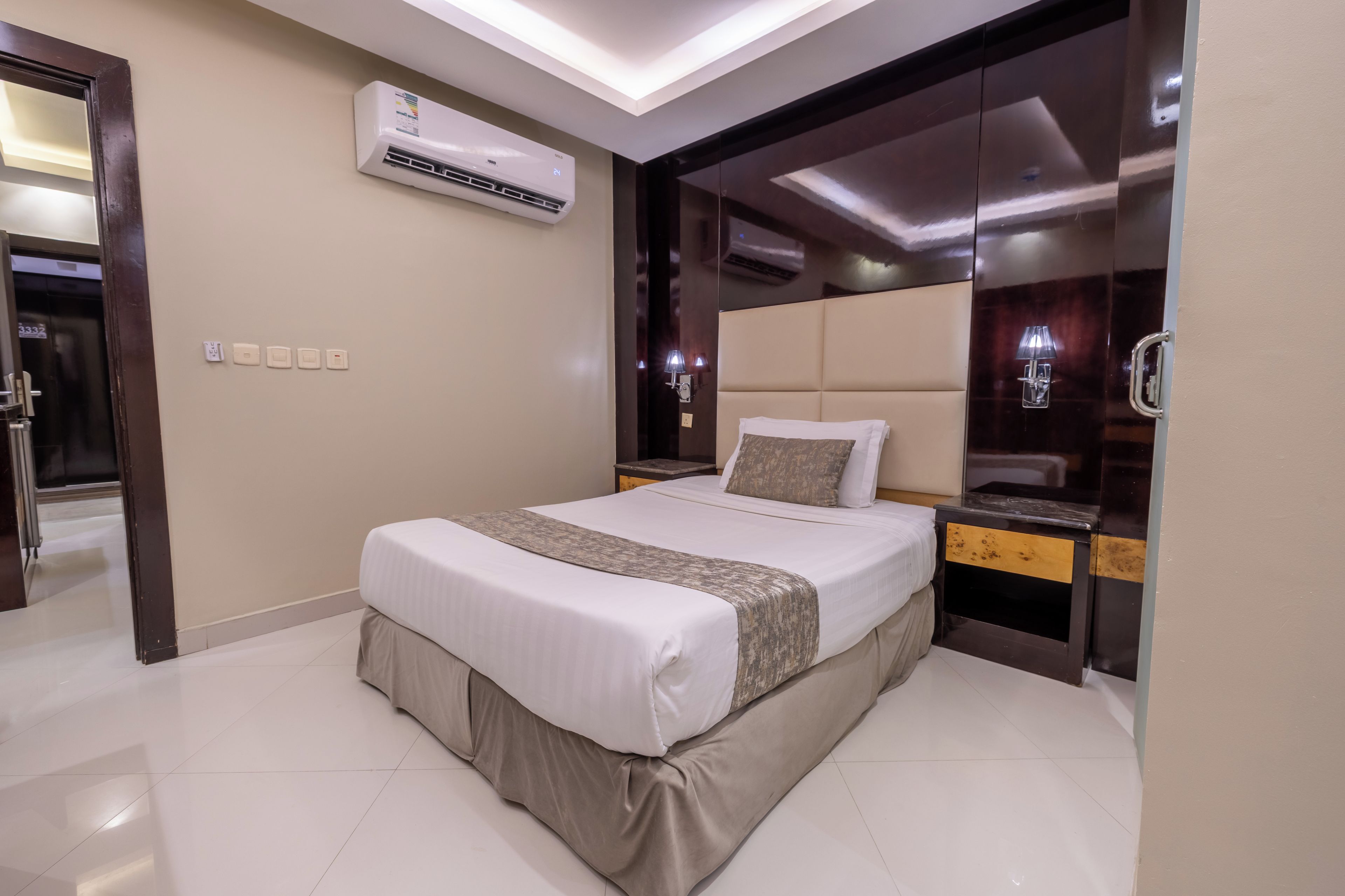 Une chambre d’hôtel moderne dotée d’un grand lit, d’une armoire intégrée et d’un système de climatisation.