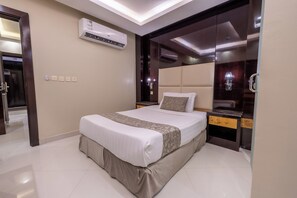 A modern hotel room with a large bed, a built-in wardrobe, and an air conditioning unit. - Al Muhaidb Residence Al Takhasossi 2 - Economic (Riyadh)