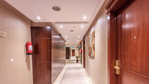 A hotel corridor with a fire extinguisher, a door, and a sign indicating room number 501. - Al Muhaidb Residence Al JAWAZAT  1 - Economic (Riyadh)