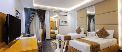 A hotel room with a bed, bedside tables, a TV, a desk, and a mirror.