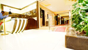A hotel lobby with a reception desk, a red carpet, and a potted plant. - Sama Al Qasr Khorais - Economic (Riyadh)
