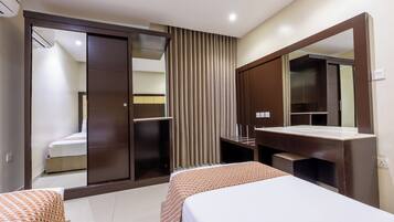 A hotel room with a bed, a wardrobe, a mirror, and a bathroom.