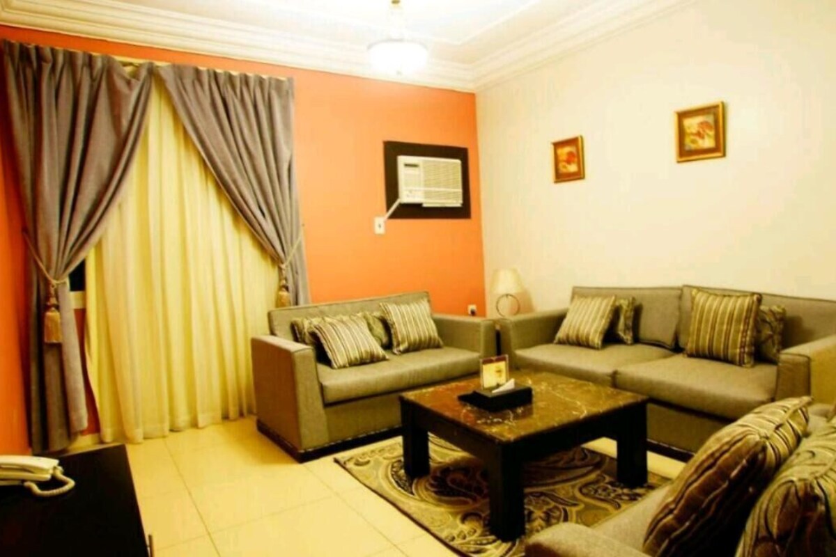 A living room with two sofas, a coffee table, a lamp, and a telephone.