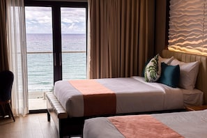 A hotel room with a bed, a chair, and a view of the ocean. - Puerto de San Juan Beach Resort Hotel and Residences La Union (San Juan)