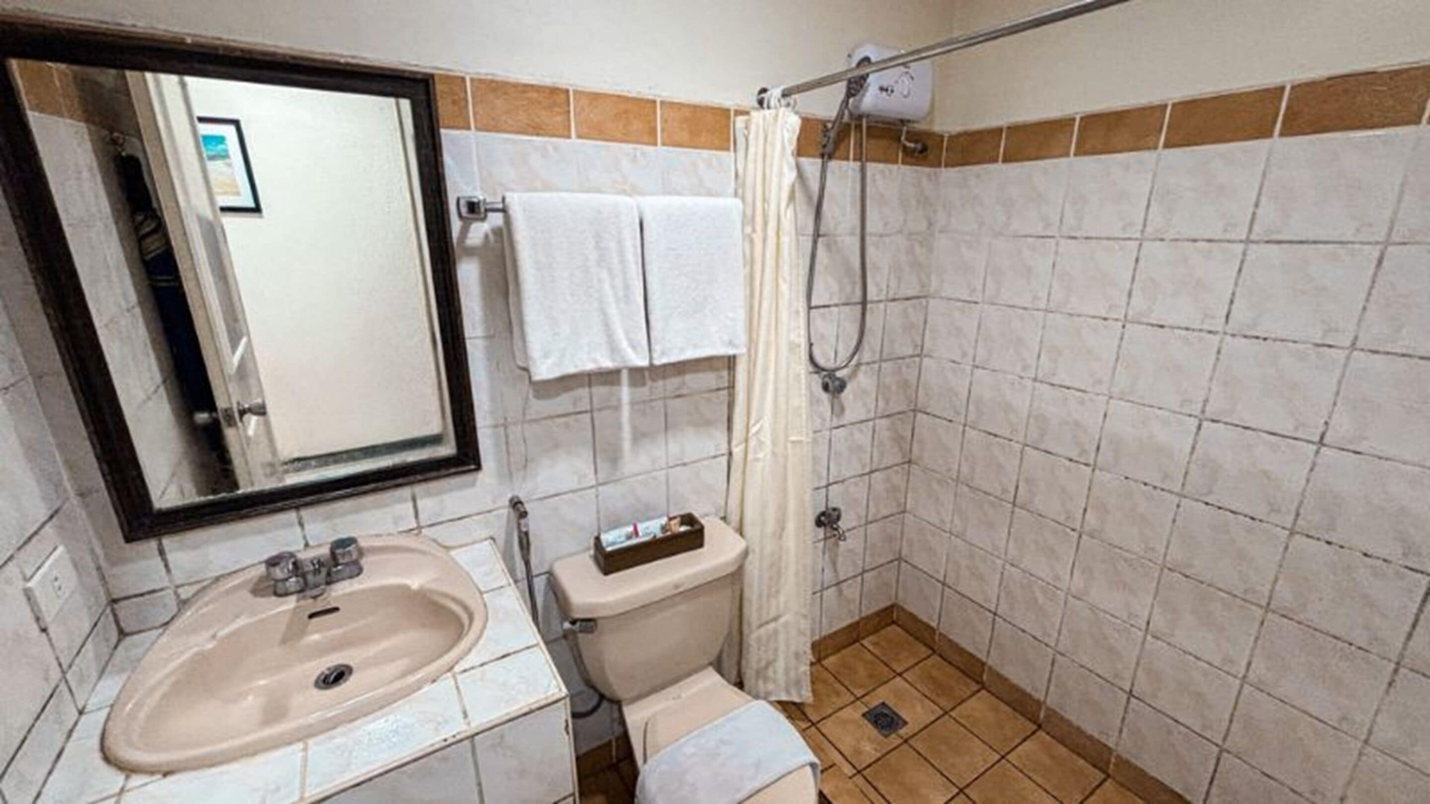A bathroom with a sink, toilet, and shower.
