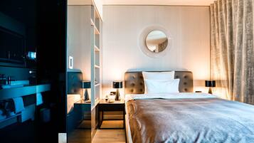 Une chambre d’hôtel moderne avec un grand lit, un grand miroir rond au mur, une table de chevet et une armoire.
