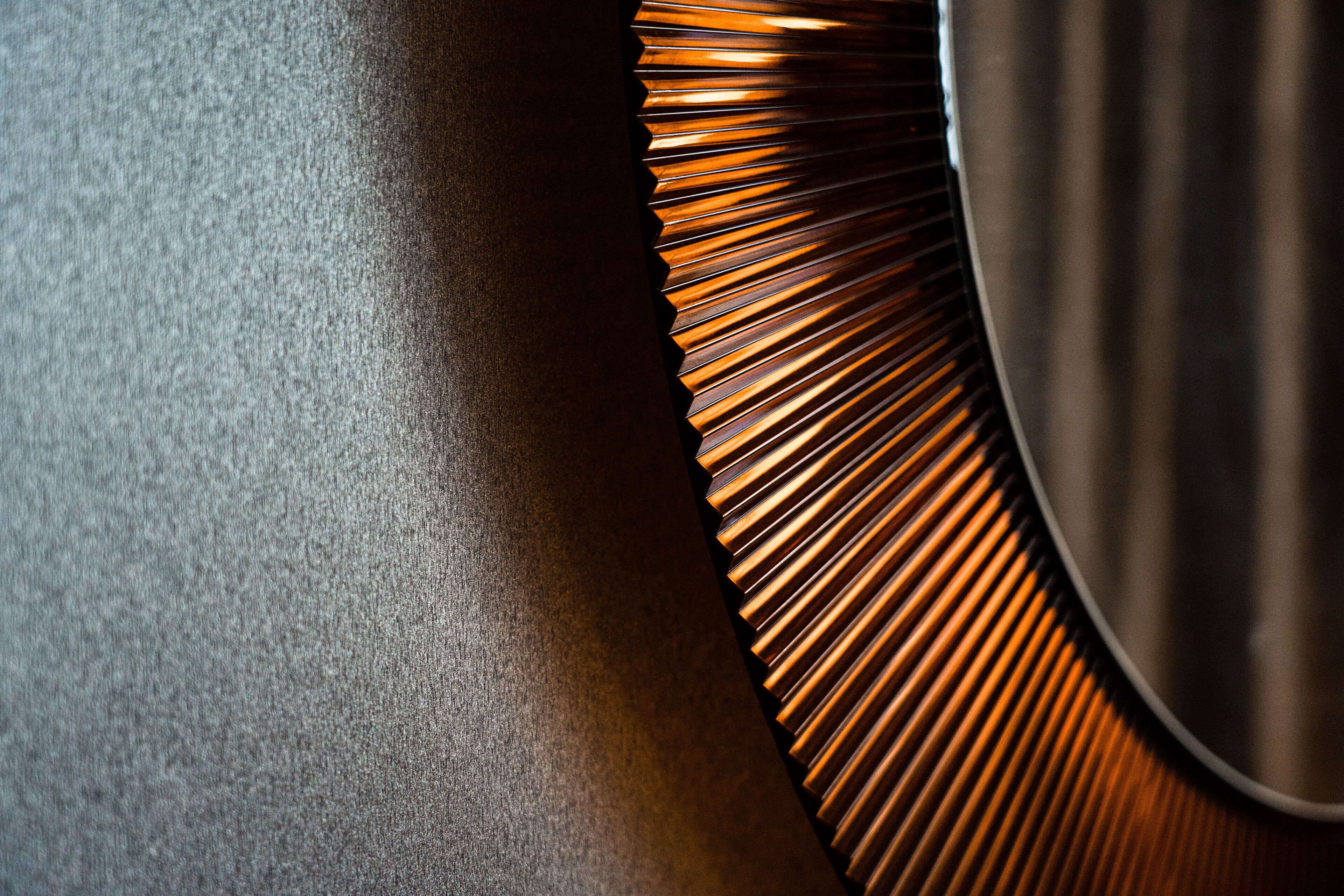 A close-up of a textured wall with a metallic, ribbed design element.
