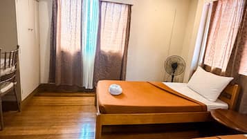 A hotel room with two beds, a desk, and a chair.