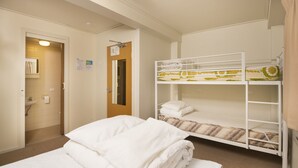 A hotel room with a bunk bed, a single bed, a bathroom with a sink, and a door leading to another room.