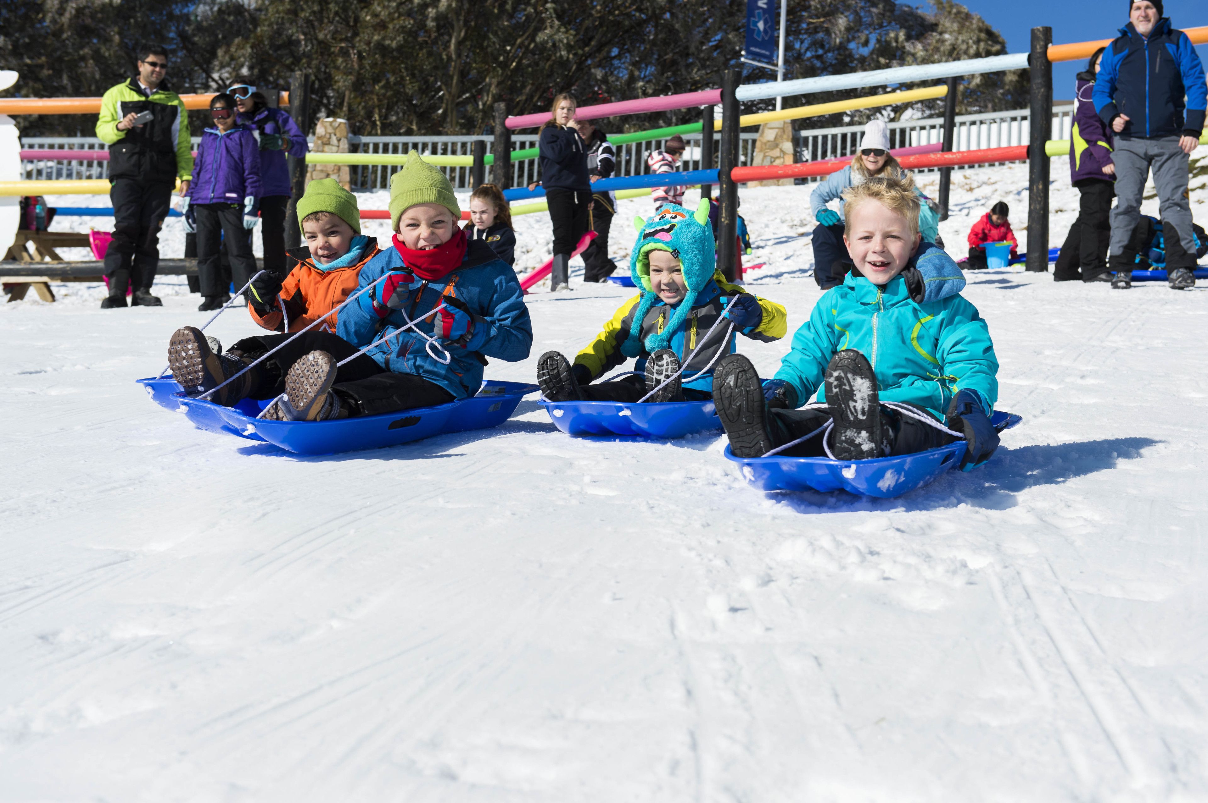Des enfants font de la luge sur un terrain enneigé.