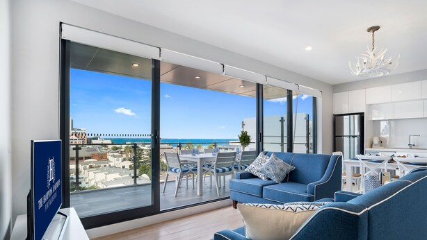 Ein modernes Wohnzimmer mit großem Balkon, Essbereich und Küche.