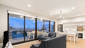 Ein modernes Wohnzimmer mit großem Fenster, einer Couch und einem Essbereich mit weißer Möbel.