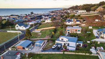 Un barrio residencial con casas, una calle y una masa de agua al fondo.