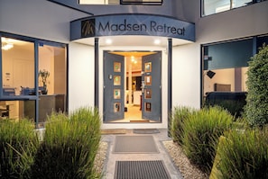 A building entrance with a sign reading 'Madsen Retreat.' - Madsen Retreat (Penguin)