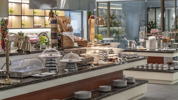 Een buffetopstelling met diverse gerechten en bestek.